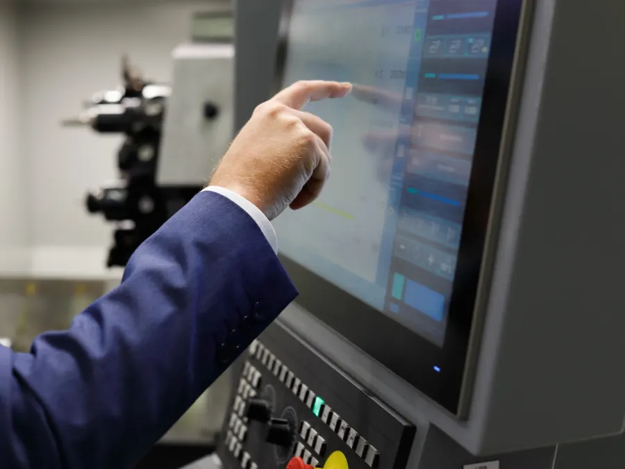 Operator bedient een touchscreen van een machinebesturing